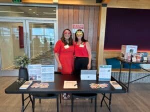 Nourish to Flourish Registered Dietitians at a wellness fair with a display of nutrition materials.